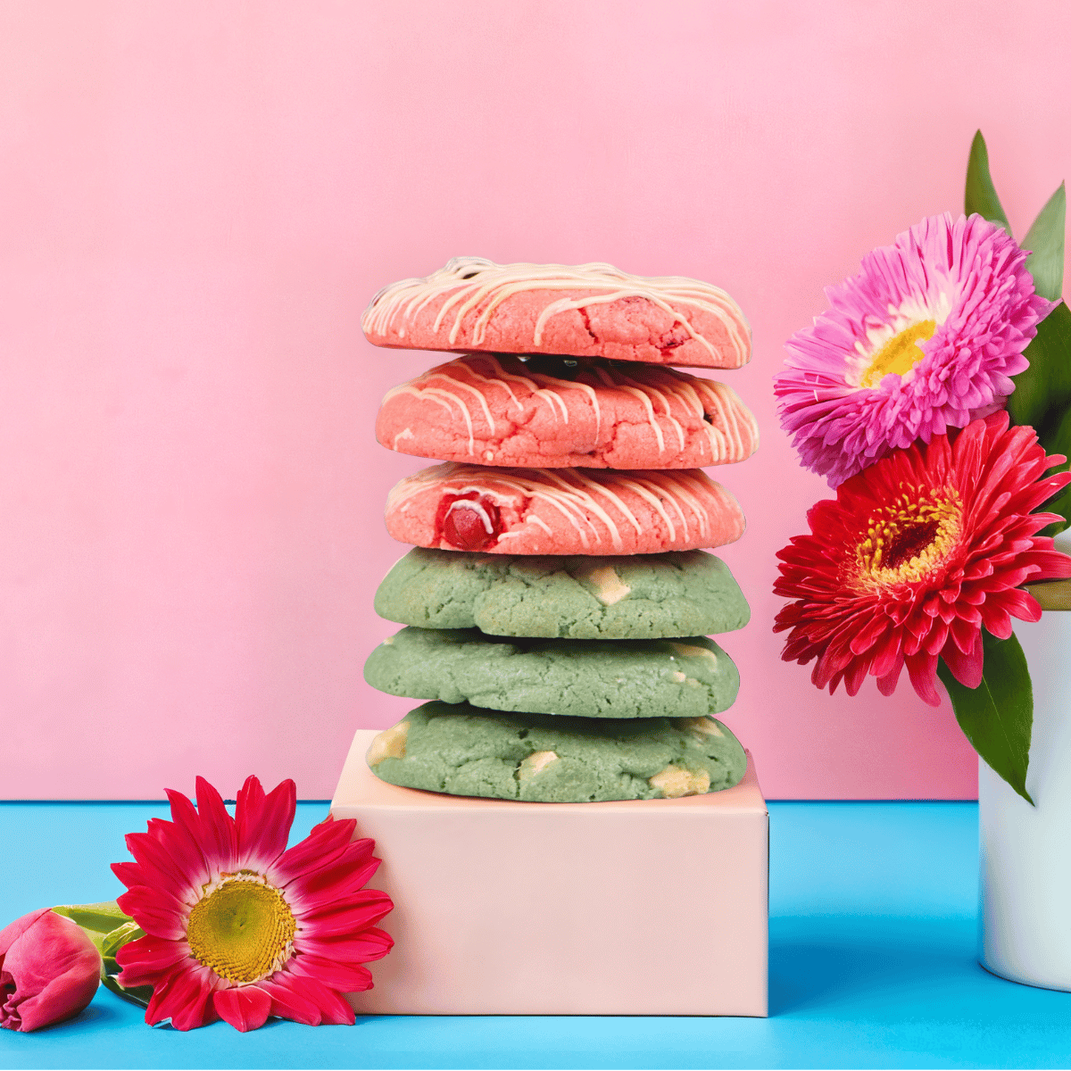 A stack of colorful Cravory cookies with fresh flowers